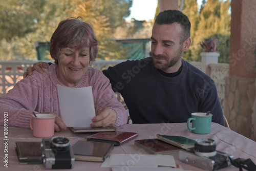 Fotografie Mother and son looking at an old photograph and reliving precious moments