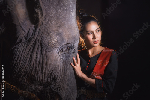 Close-up portrait of a Beautiful woman affectionately touching an elephant's head, Surin, Thailand