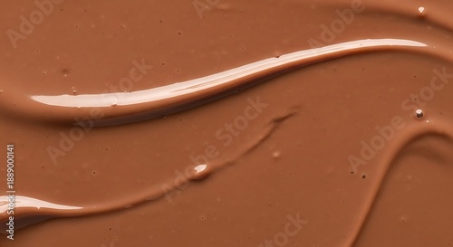 Smooth creamy milk chocolate texture with glossy waves and swirls on a brown background