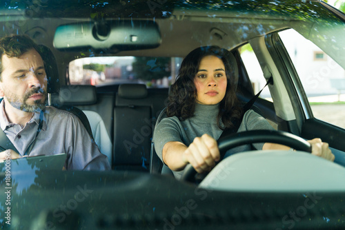 Foto Nervous woman learning driving skills with male instructor assessing her progres