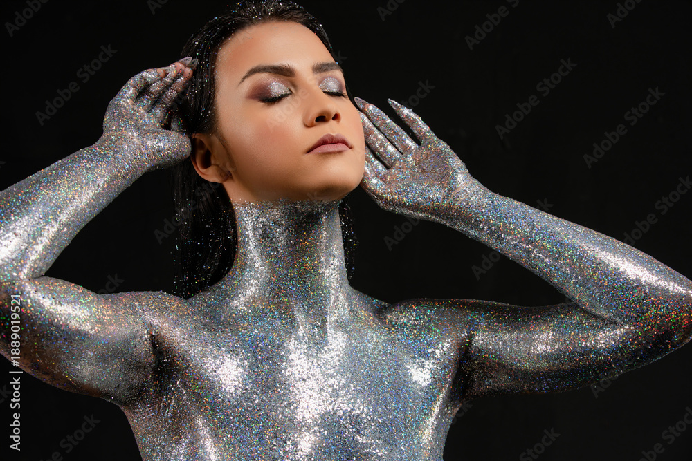 custom made wallpaper toronto digitalPortrait of a serene woman with closed eyes, her body covered in sparkling silver glitter against a black background.