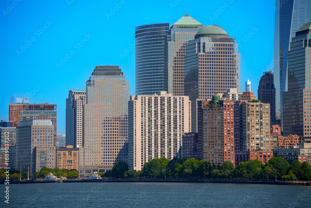 Fototapeta premium Abstract urban background featuring a dense cluster of modern skyscraper facades with geometric window patterns in golden evening light, New York City.