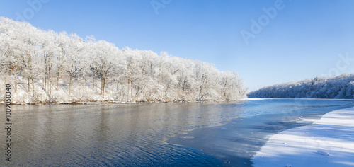 Snow-covered forest alongside a river