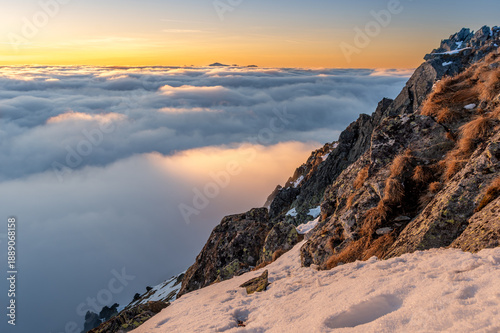 Winter sunset view of High Tatra mountains, with valleys filled by clouds, seen from Szpiglasowy Wierch over Koprova valley, Poland, Slovakia