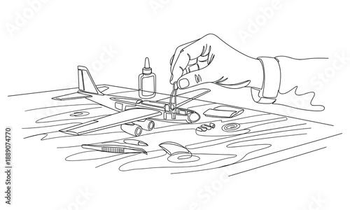 Hand assembling a model airplane kit with glue and parts, detailed hobby project