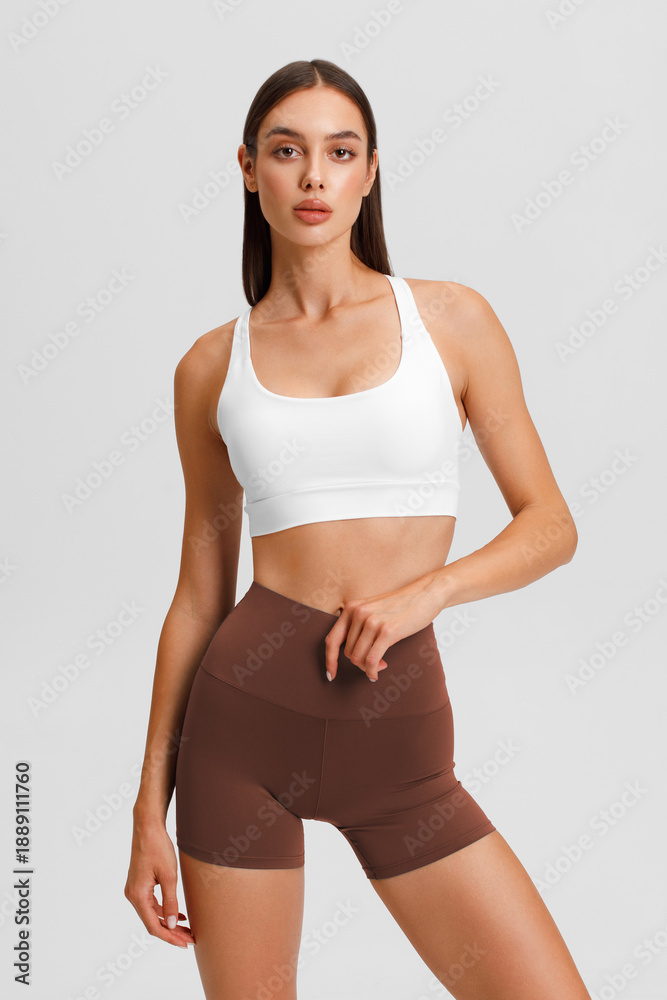 Fototapeta premium Athletic girl on the gray background. Fitness woman