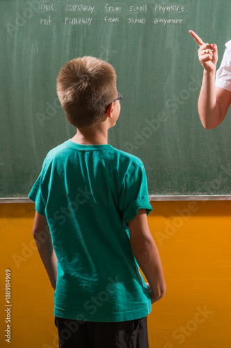 Foto Back view of a child in front of a blackboard with text