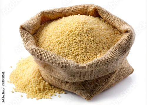 A rustic burlap sack filled to the brim with small yellow couscous grains, spilling onto a clean white surface.