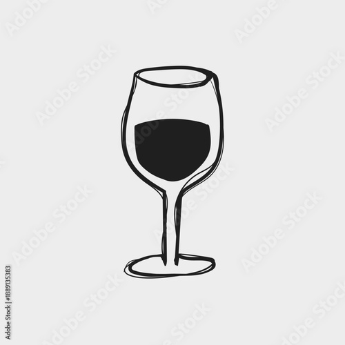 Wine glass sits on a table with dark liquid inside during a quiet evening gathering with friends and family at home