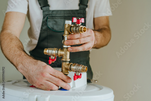 Canvas-taulu Installation of plumbing fittings on water heater by master