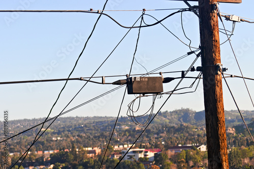 Φωτογραφία Utility lines and a wooden power pole cross a suburban hillside view in Riverside County, California, highlighting everyday urban infrastructure