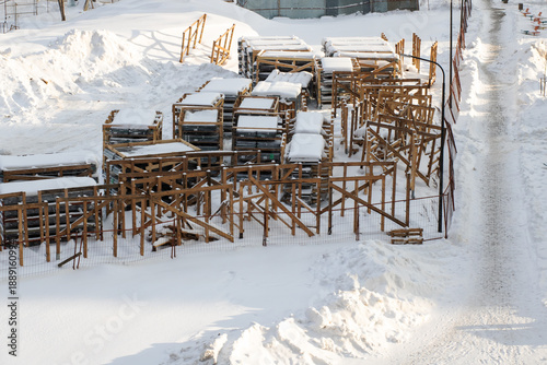 Photos Silent and snowy construction site with frosted wooden beams standing unmoving o