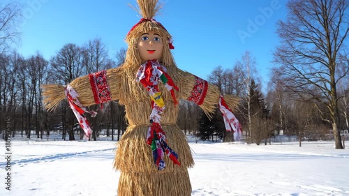 Traditional straw effigy in winter park under blue sky