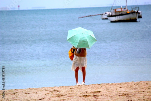 Woman holding a turquoise color umbrella