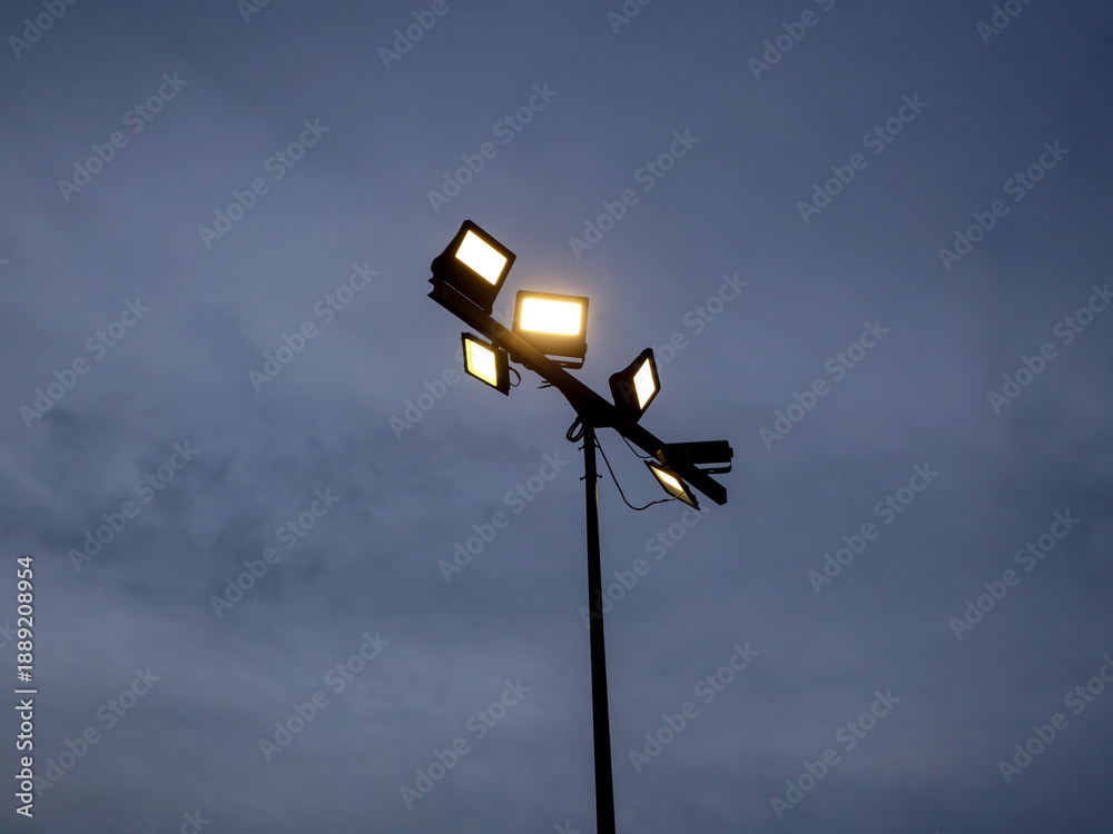 Fotografie Bright Floodlights Against Dusk Sky