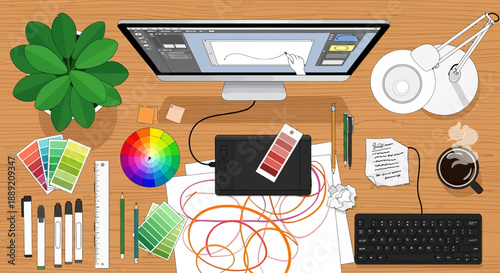 Digital artist's workspace with graphic tablet, color palette, and creative tools on wooden desk