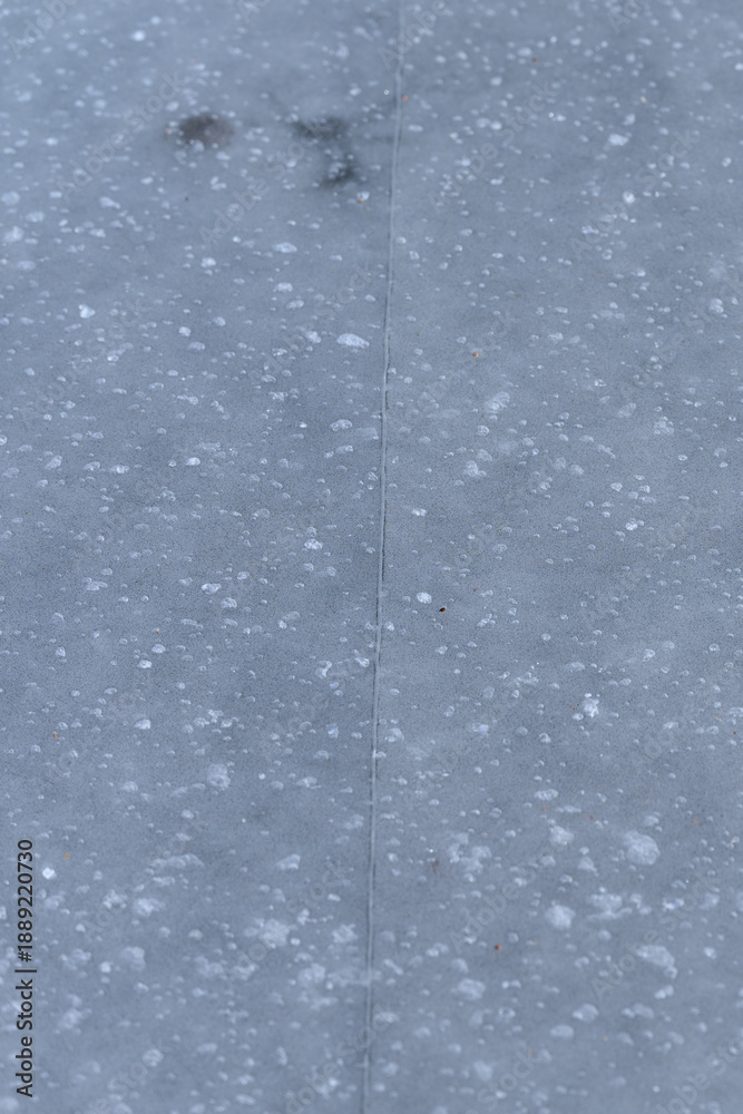 Fototapeta premium A crack in the ice with bubbles on a pond.