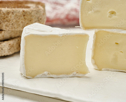 Sliced ​​round head of Camembert cheese on a white board