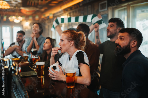 Принти на полотні Young friends watching football game in sports bar