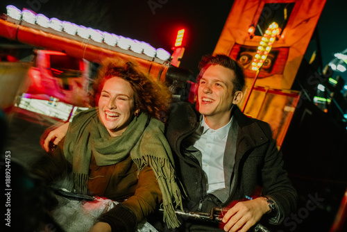 Bilde på lerret Cheerful couple enjoying spinning ride at amusement park