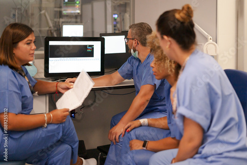 Medical team collaborating analyzing patient data on monitor