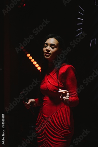 Фотография Female singer performing live in red dress