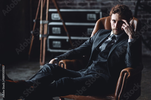 Canvastavla Portrait of a handsome young stylish sexy man in a white shirt, , suit, jacket posing in studio with a loft interior
