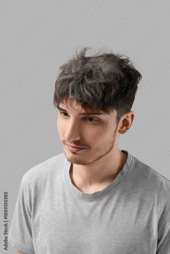 Fototapeta premium Young man with graying hair on light background