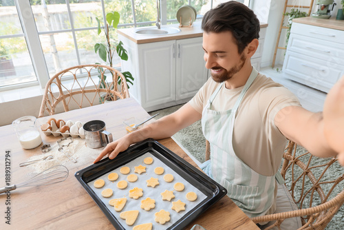 Young man with raw cookies ...