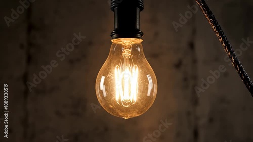 Flickering light bulb. A single exposed light bulb flickering on and off in a dark, empty space, briefly illuminating surrounding darkness.