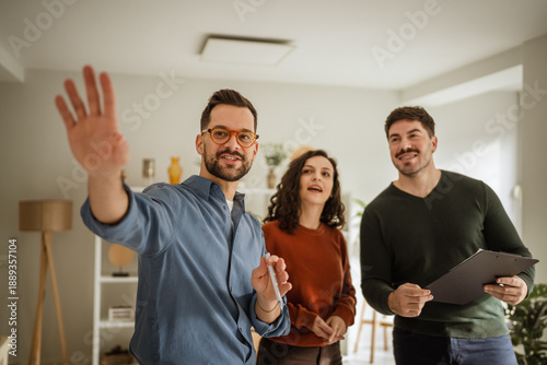 Fényképezés Real estate agent showing potential home to young couple