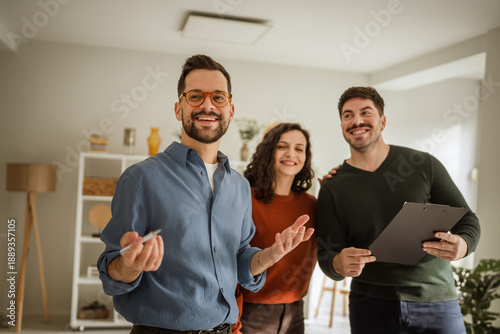 Fotografie Real estate agent showing potential home to young couple