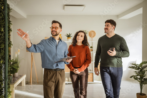 Real estate agent showing potential home to young couple