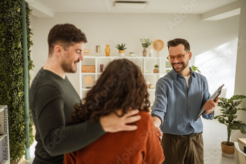 Photos Real estate agent shaking hands with couple, closing deal