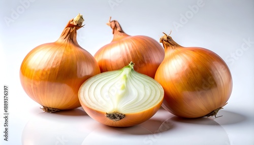 Wallpaper Mural Four yellow onions, one cut in half, sit on a white surface, highlighted by a strong light Torontodigital.ca