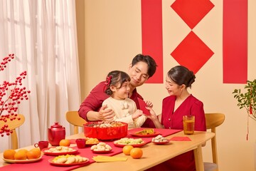 Close family moment during Lunar New Year, red decorations and food setting the festive mood. The custom of giving lucky money envelopes to wish good health.