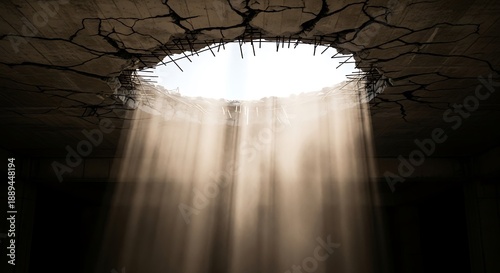 Sunlight streaming through a circular hole in a cracked concrete ceiling. Concept of hope, divine inspiration, liberation, and finding a spiritual breakthrough in a dark industrial space.