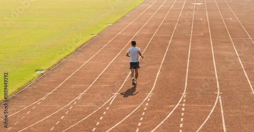 Photos A man runs alone on a track showcasing fitness and determination in a solo pract