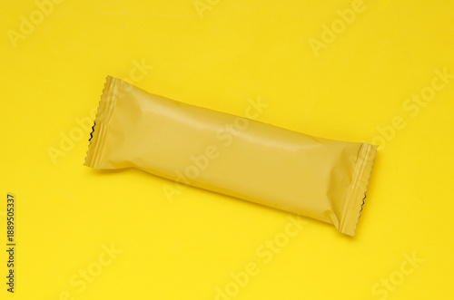 Chocolate bar pack mockup on yellow background. Blank yellow candy wrapper