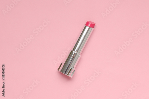 Tube of pink lipstick on a pink background