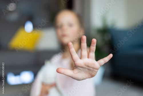 Fotografia Young girl showing open hand gesture in a living room