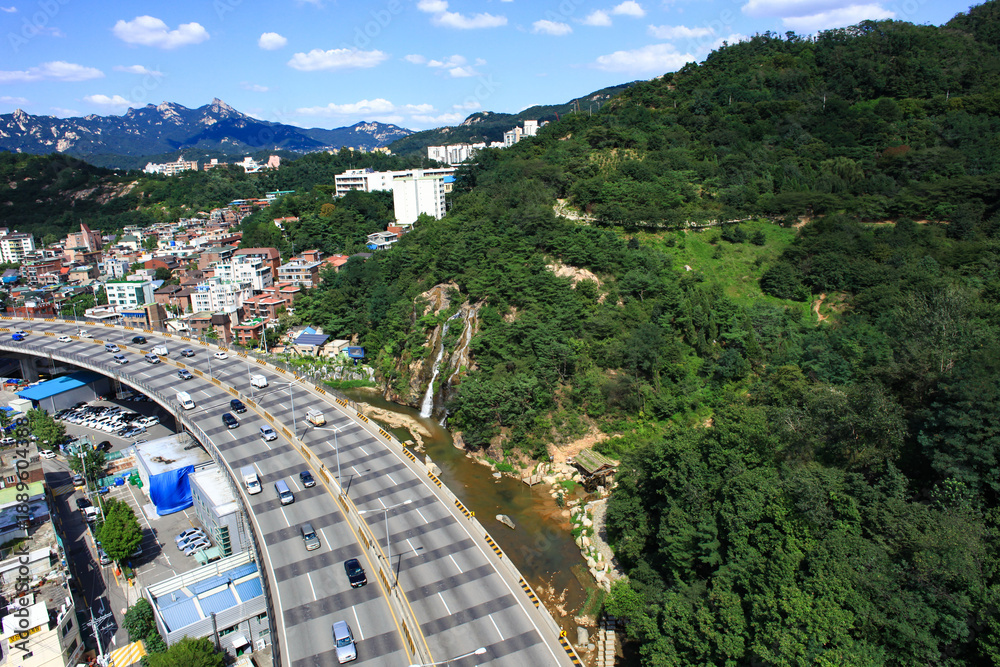 Fototapeta premium Aerial view of Bukhansan Mountain and Seoul city skyline under clear blue sky
