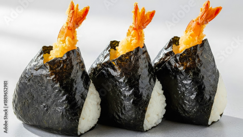 白い背景に並べられた、海苔で包んだ海老天入り天むすおにぎり3個