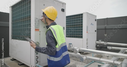 HVAC technician performs maintenance on industrial HVAC equipment in urban setting. Technical expertise and safety measures involved in upkeep of heating, ventilation, and air conditioning systems.
