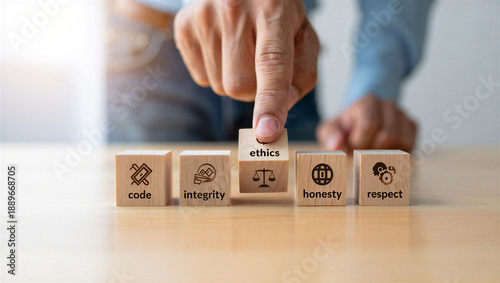 hand placing ethics block on table with code integrity honesty respect