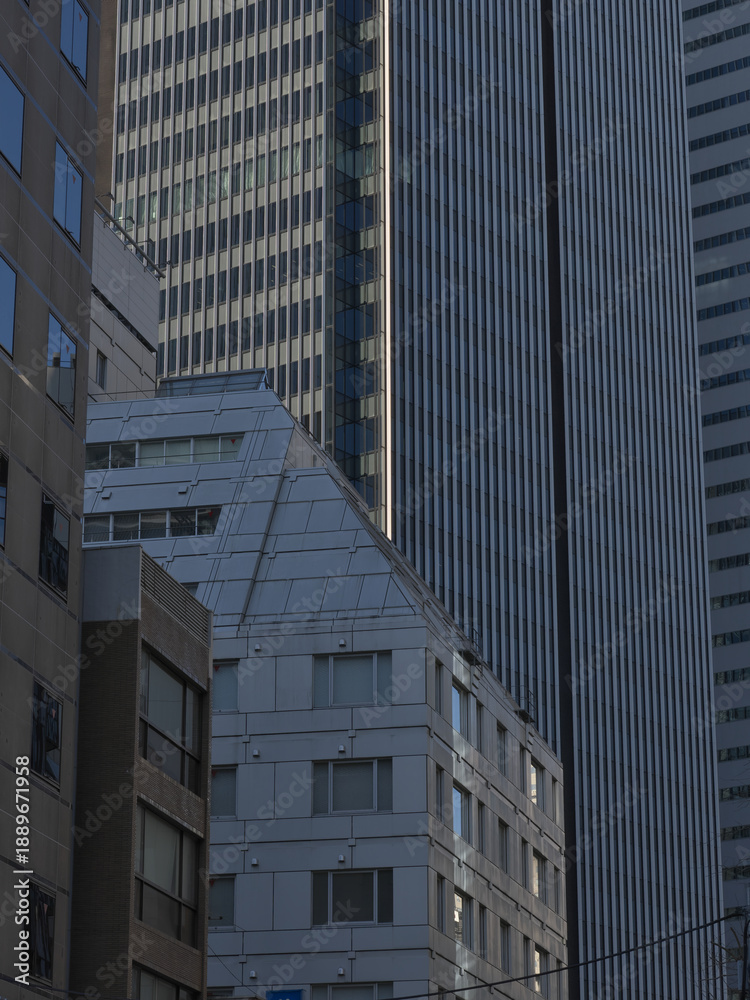 Obraz premium 都会にそびえ立つ高層ビル群の幾何学的な重なりとモダンな建築デザイン