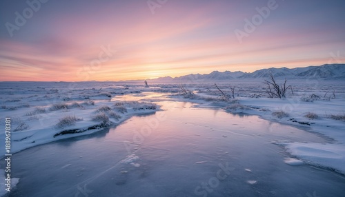 A serene winter landscape with a frozen stream reflecting a vibrant sunset, mountains in background