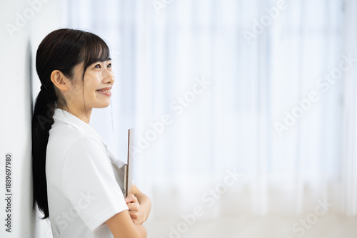Side View of Smiling Young Woman in White Uniform Holding Clipboard Free Download Side View of Smiling Young Woman in White Uniform Holding Clipboard - GFXLoad