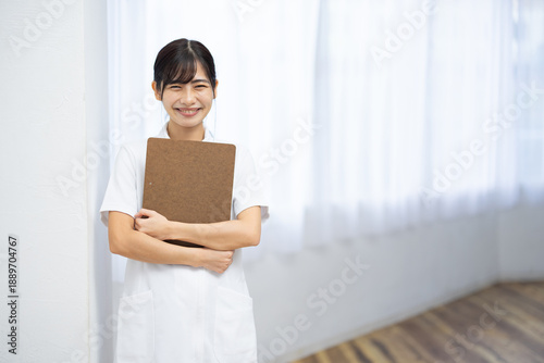 Smiling Young Woman in White Uniform Holding Clipboard Free Download Smiling Young Woman in White Uniform Holding Clipboard - GFXLoad