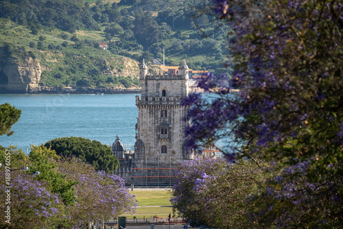 Картината върху платно Belém Tower Framed by Jacaranda Trees in Lisbon, Portugal
